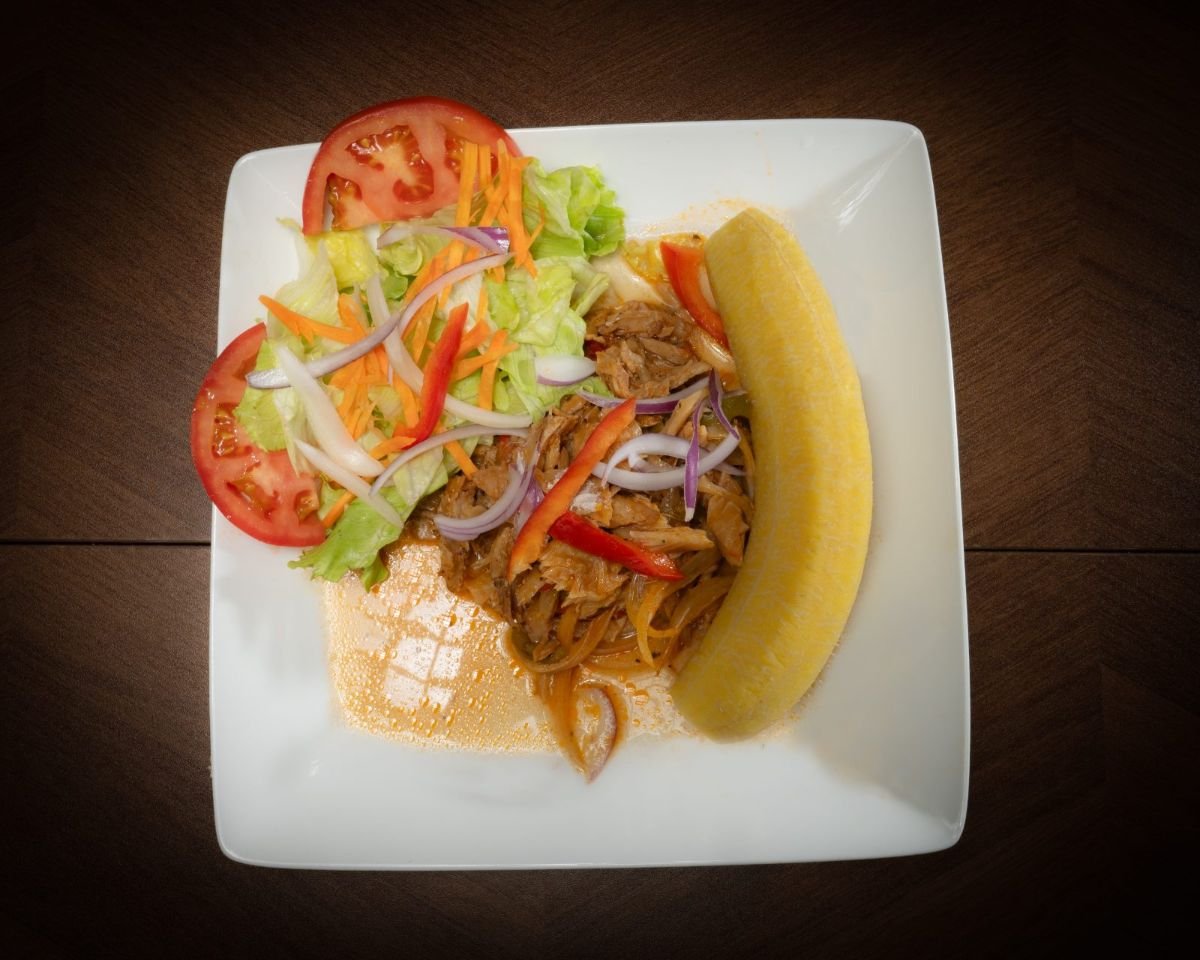 Haitian saltfish and plantain catering plate with fresh vegetables at Chez Le Bebe in Miami