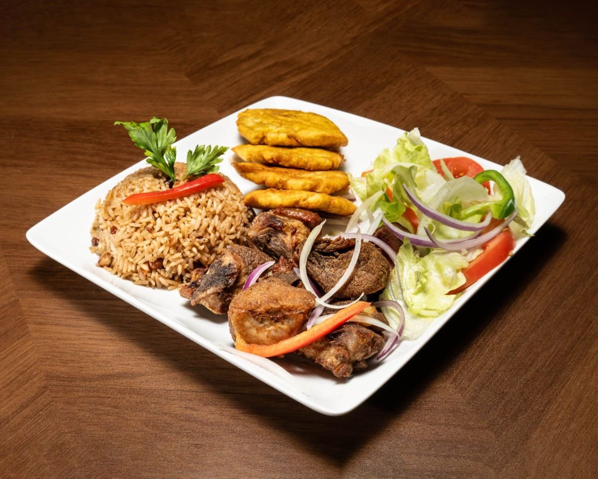 Haitian griot fried pork with rice and beans, fried plantains, and fresh salad at Chez Le Bebe in Miami