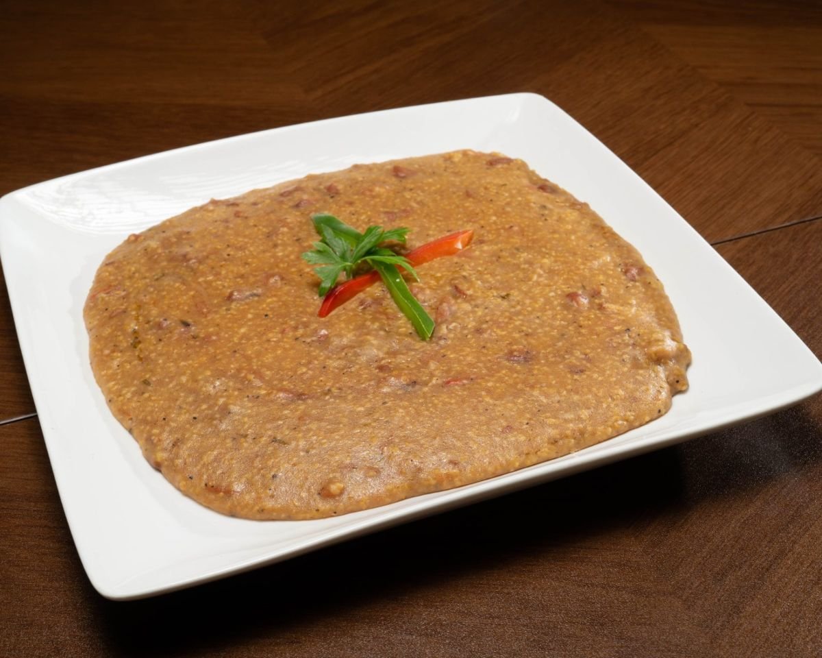Mayi moulen, creamy Haitian cornmeal, served on a white plate at Chez Le Bebe in Miami
